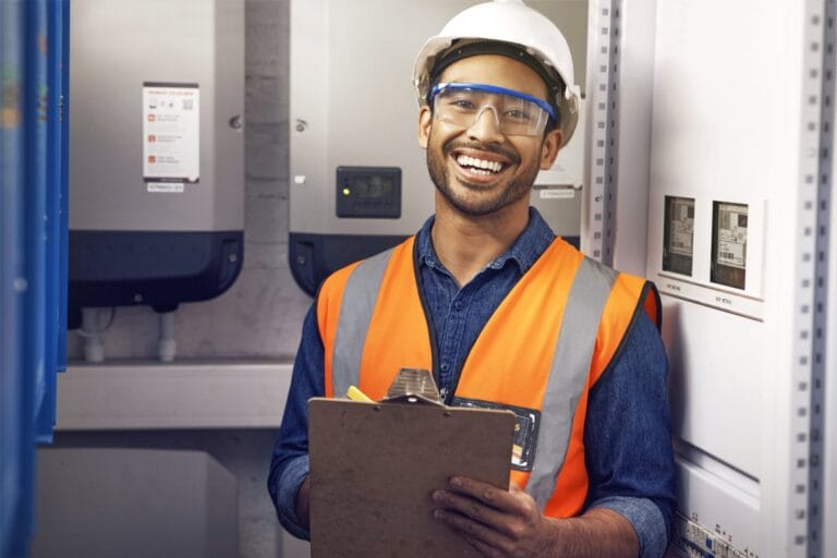 Ein Installateur während der Montage und Inbetriebnahme von Batteriespeicher und Wechselrichter im Keller eines Hauses.